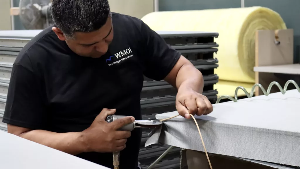 WMOI team member installs new fabric to a panel during an office refurb and refresh