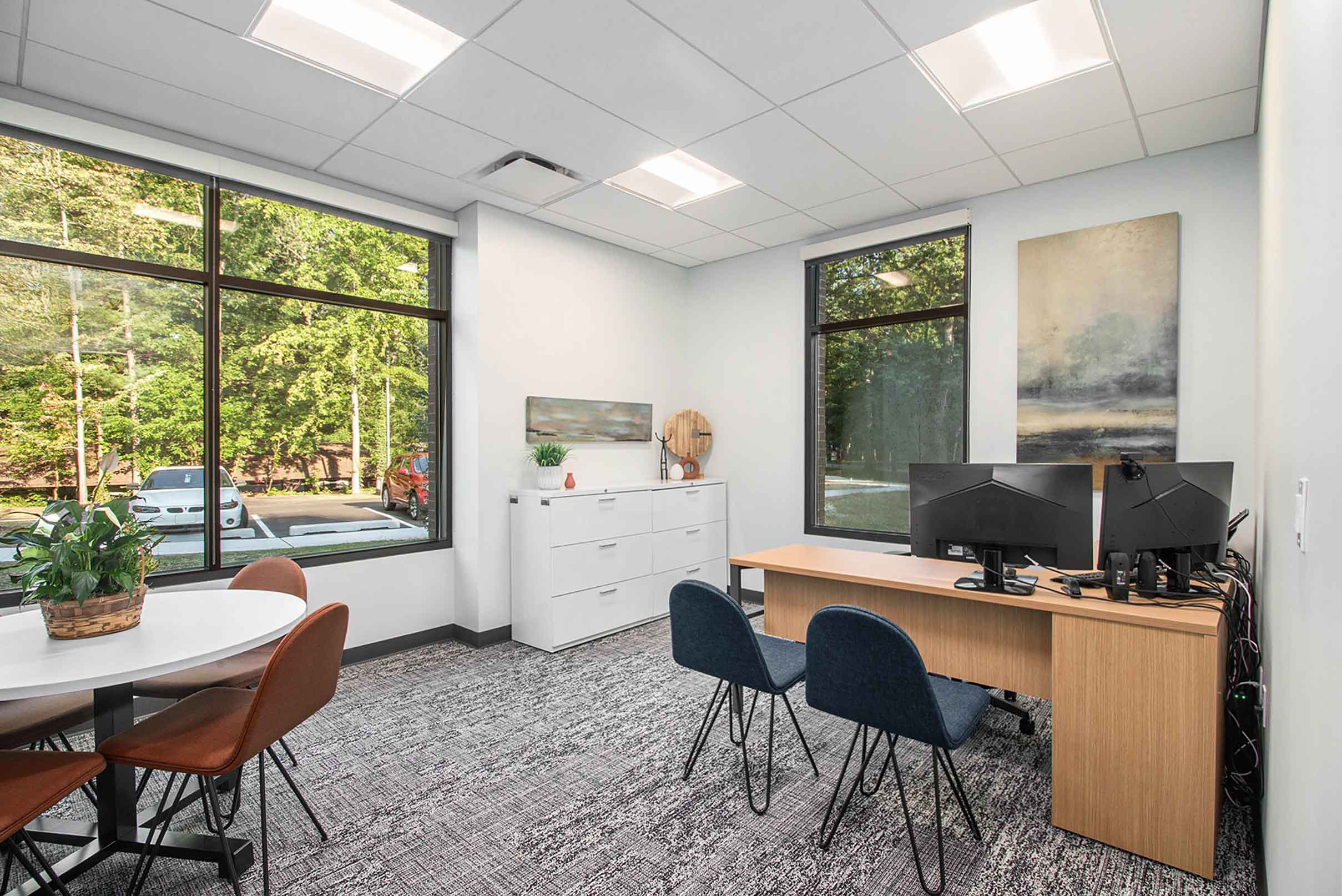 Private office with desk, table, storage and seating.