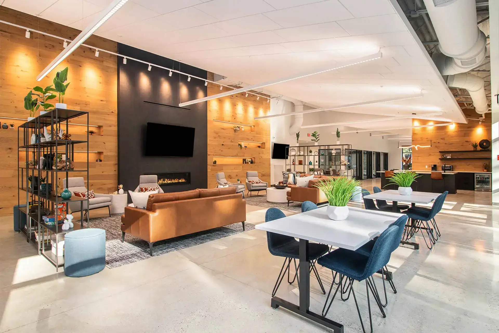 Hospitality lounge with modern seating, communal tables, and warm wood finishes