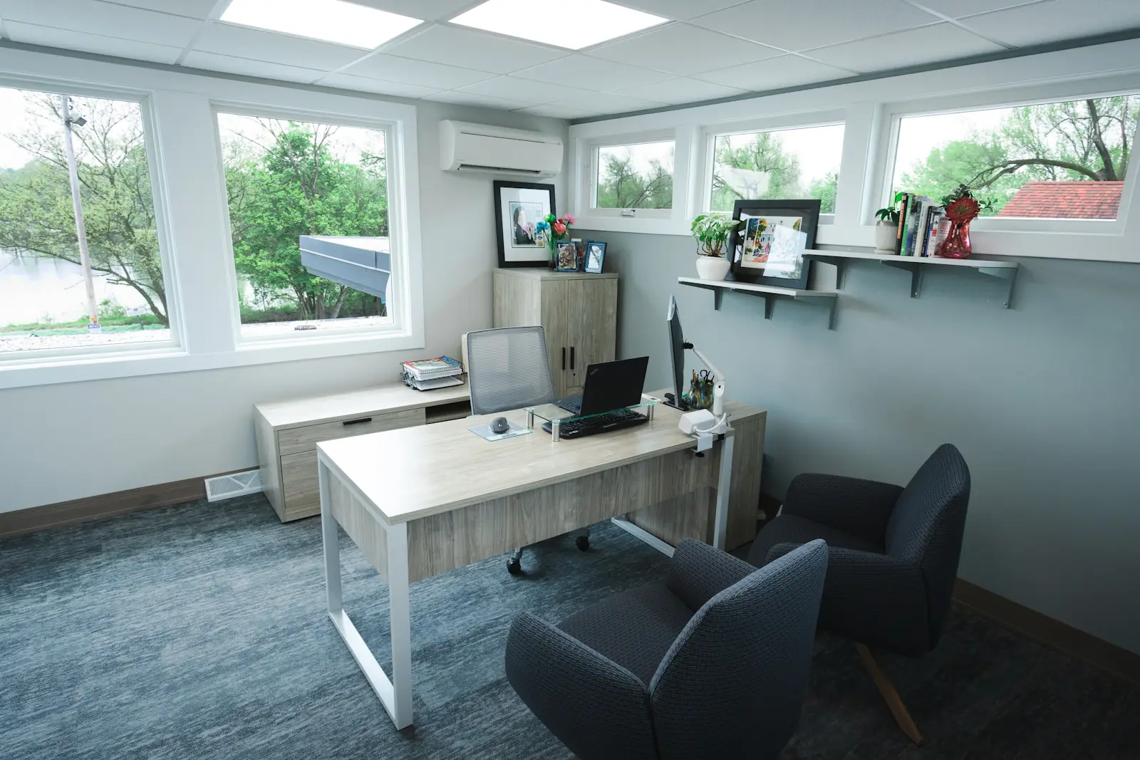 Private commercial office with desk, guest seating, and natural light