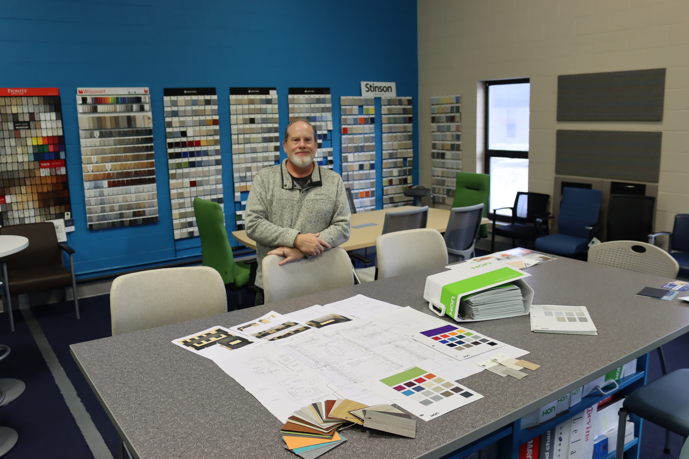 Lounge seating area inside the Kalamazoo showroom with a curved sofa, upholstered chairs, and a round table