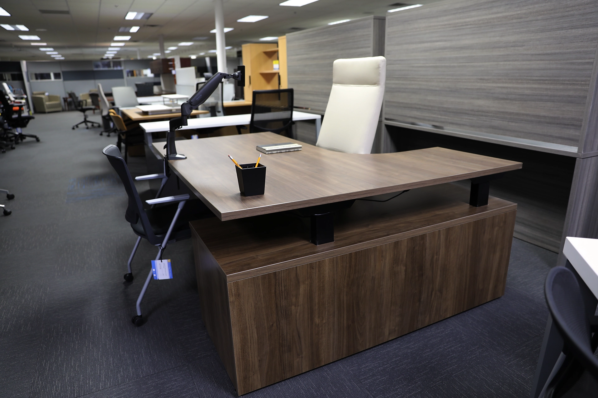 Executive desk setup inside the Holland, Michigan showroom, showing a workstation with seating and surrounding office furniture.