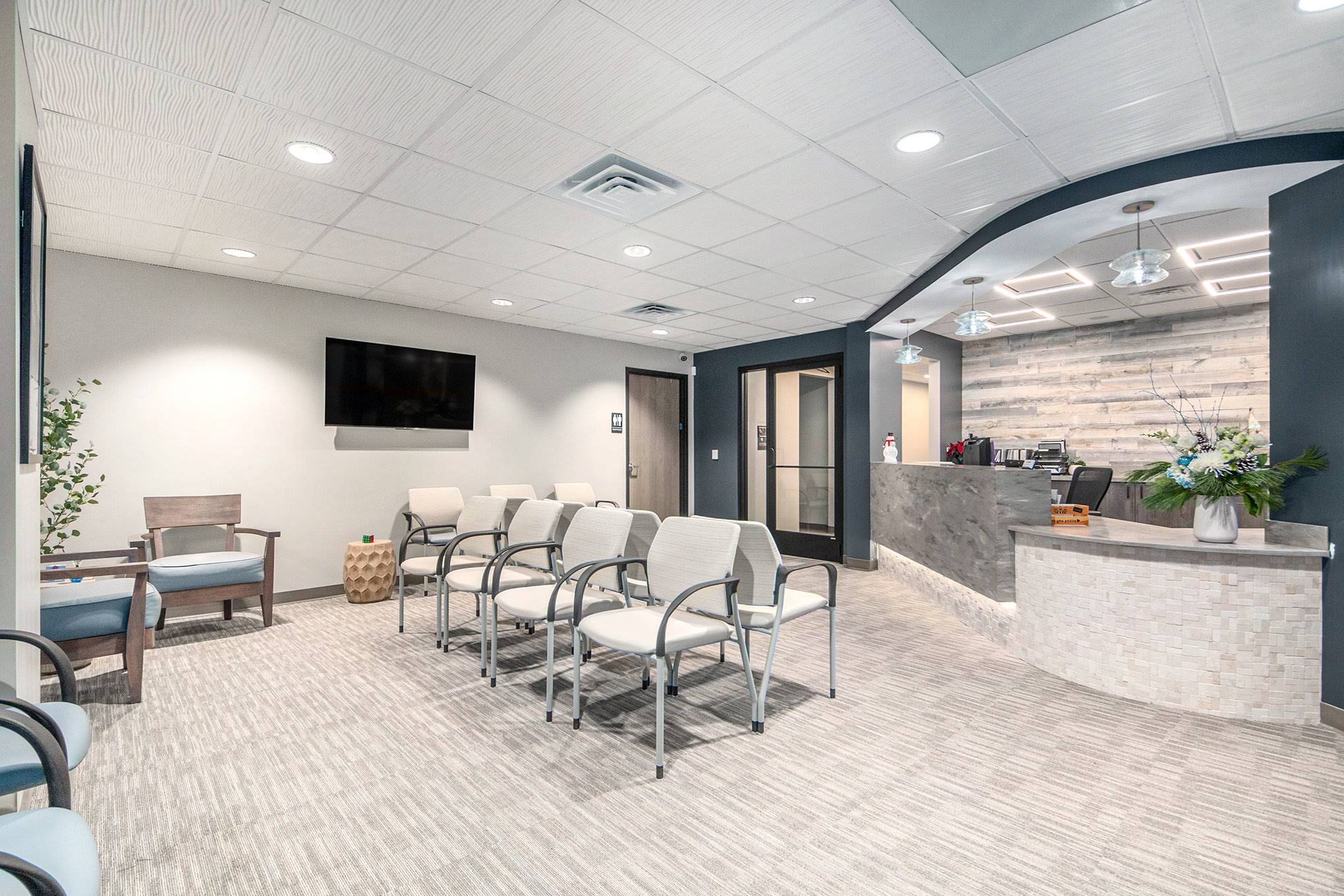Healthcare waiting area with reception desk, patient seating, and modern finishes