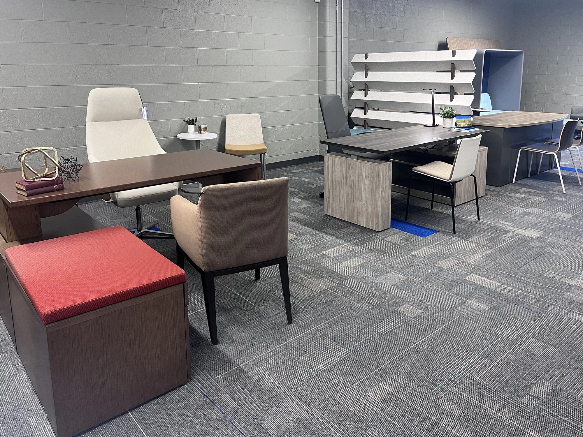 Executive desk setup inside the Holland, Michigan showroom, showing a workstation with seating and surrounding office furniture.