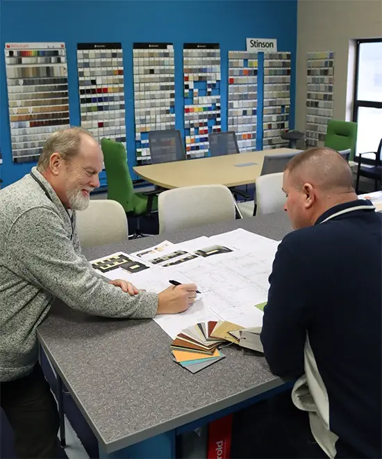 Project manager reviewing office furniture installation plans with a client