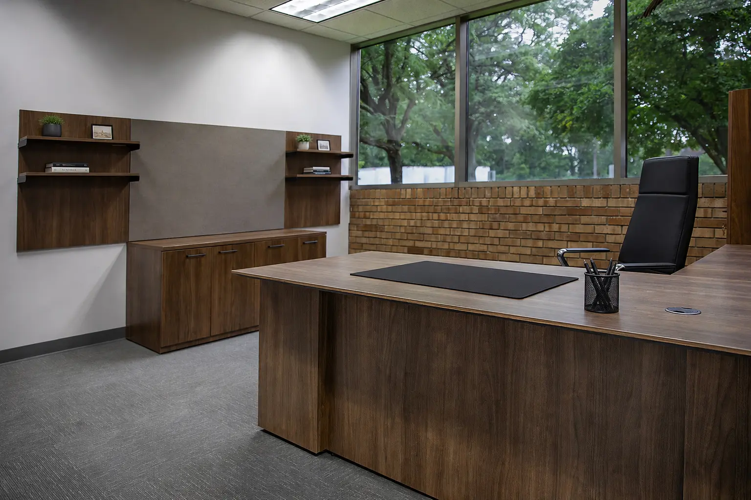 Executive desk setup inside the Holland showroom, showing a workstation with seating and surrounding office furniture.