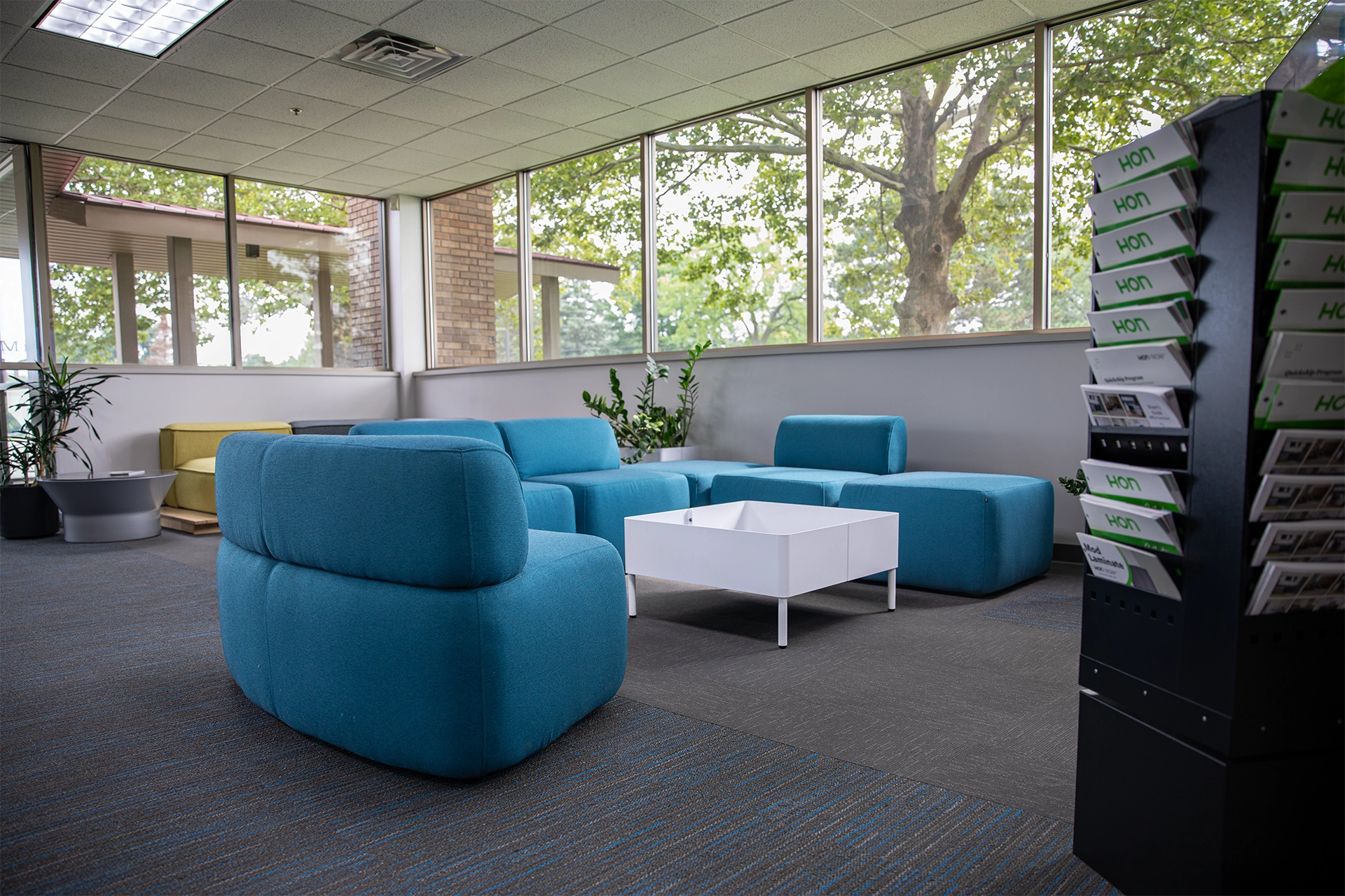 Modular lounge seating display with blue lounge seating and white table. 