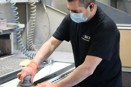 Worker sanding surface as part of remanufacturing process.